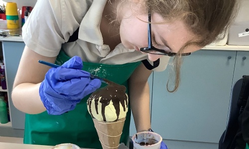 Student from Mercury Class painting her ice cream sculpture